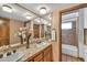 Bathroom featuring double sinks, a large mirror and tile countertops and walls at 7037 N 11Th Dr, Phoenix, AZ 85021