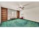 Bedroom with green carpet, built-in wood bookshelves and a ceiling fan at 7037 N 11Th Dr, Phoenix, AZ 85021