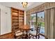 Dining area with wood floors, bookshelf, and access to the outdoor patio, creating a cozy and connected living space at 7037 N 11Th Dr, Phoenix, AZ 85021