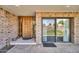 Inviting entryway with wood door, brick accents, and large window, creating a warm and welcoming ambiance at 7037 N 11Th Dr, Phoenix, AZ 85021