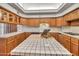 Spacious kitchen with island, white tile countertops, and wood cabinets, offering ample space for cooking and entertaining at 7037 N 11Th Dr, Phoenix, AZ 85021