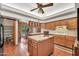 Open-concept kitchen with a kitchen island, tile floors, wood cabinetry, and a view into the dining area at 7037 N 11Th Dr, Phoenix, AZ 85021