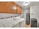 Laundry room featuring washer, dryer, tile floors, water heater, and storage cabinets at 7037 N 11Th Dr, Phoenix, AZ 85021