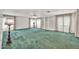 Bright living room with green carpet, sheer curtains, and built-in shelving at 7037 N 11Th Dr, Phoenix, AZ 85021