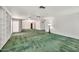 Open living room with green carpet, built-in shelves, and chandelier lighting at 7037 N 11Th Dr, Phoenix, AZ 85021