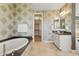 Bathroom showcases a soaking tub, vanity with storage, and a doorway leading to the walk-in closet at 7122 W Ivanhoe St, Chandler, AZ 85226