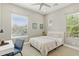 Bright bedroom with a ceiling fan, two sunny windows, a bed and a desk for working from home at 7122 W Ivanhoe St, Chandler, AZ 85226
