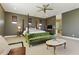 Spacious primary bedroom featuring a four poster bed, seating area, ceiling fan, and en-suite bathroom at 7122 W Ivanhoe St, Chandler, AZ 85226