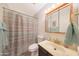 Bathroom features a single sink, striped shower curtain, medicine cabinet with vanity lighting at 730 W Curry St, Chandler, AZ 85225