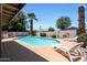 Backyard pool with tanning deck, palm trees, and a block wall fence, providing a private outdoor retreat at 730 W Curry St, Chandler, AZ 85225