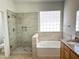 Bathroom featuring a glass enclosed shower, soaking tub and travertine-style tile at 7419 S 45Th Ave, Laveen, AZ 85339