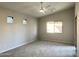 Spacious bedroom features neutral carpeting, a fan, and multiple windows for plenty of natural light at 7419 S 45Th Ave, Laveen, AZ 85339