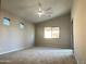 Expansive bedroom features neutral carpet, ceiling fan, and multiple windows for an airy and bright atmosphere at 7419 S 45Th Ave, Laveen, AZ 85339