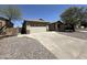 Exterior shot of home with two-car garage, neutral paint, rock landscaping, and wide driveway at 7419 S 45Th Ave, Laveen, AZ 85339