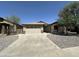 Street view of the home featuring a two-car garage, rock landscaping, and wide driveway at 7419 S 45Th Ave, Laveen, AZ 85339