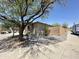 A side view showing the desert landscaping, brick walls, and mature trees that surround the home at 7419 S 45Th Ave, Laveen, AZ 85339