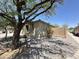 A side view showing the desert landscaping, brick walls, and mature trees that surround the home at 7419 S 45Th Ave, Laveen, AZ 85339