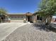 Charming single story home featuring a two-car garage, desert landscaping, and stone accents at 7419 S 45Th Ave, Laveen, AZ 85339