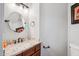Charming powder room featuring a granite countertop, bronze fixtures, and oval mirror at 758 S Lagoon Dr, Gilbert, AZ 85233