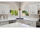 Bright kitchen featuring white marble countertops and a black undermount sink below large windows at 758 S Lagoon Dr, Gilbert, AZ 85233