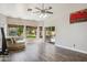 Bright living room featuring wood floors, large windows, a ceiling fan, and sliding door to the patio at 758 S Lagoon Dr, Gilbert, AZ 85233