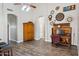 Bright living room featuring wood floors, decorative clocks, arched doorways, and unique piano-turned-desk at 758 S Lagoon Dr, Gilbert, AZ 85233