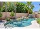Tranquil backyard pool area with lush landscaping and rock waterfall feature at 758 S Lagoon Dr, Gilbert, AZ 85233