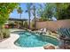 Inviting backyard pool surrounded by mature palm trees and meticulous landscaping at 758 S Lagoon Dr, Gilbert, AZ 85233