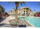 Resort-style pool featuring clear blue water, palm trees, lounge seating, and verdant landscaping at 7601 E Indian Bend Rd # 1040, Scottsdale, AZ 85250