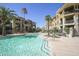 Resort-style pool view featuring clear blue water, palm trees, and comfortable lounge seating for residents at 7601 E Indian Bend Rd # 1040, Scottsdale, AZ 85250