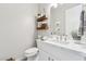 Stylish powder room featuring a floating wood shelf, marble counters, and a modern vessel sink at 8396 E Granite Pass Rd, Scottsdale, AZ 85266