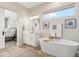 Bathroom view with soaking tub, vanity, and barn door leading to the bedroom at 8396 E Granite Pass Rd, Scottsdale, AZ 85266