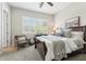Serene bedroom featuring a comfy reading chair, plantation shutters, and a wood-framed bed at 8396 E Granite Pass Rd, Scottsdale, AZ 85266