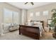 Sunlit bedroom with plantation shutters, a cozy bench, and a well-dressed sleigh bed at 8396 E Granite Pass Rd, Scottsdale, AZ 85266