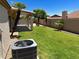 Green backyard featuring lush grass and palm trees, with a glimpse of the pool and covered patio at 9109 W Watson Ln, Peoria, AZ 85381