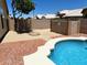 A fully fenced yard with a beautiful pool, a cozy fire pit, and an attractive, low-maintenance landscape at 9109 W Watson Ln, Peoria, AZ 85381