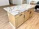 Kitchen island with seating featuring granite counters, storage and a wood-look floor at 9109 W Watson Ln, Peoria, AZ 85381