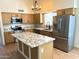 Well-lit kitchen featuring stainless steel appliances, granite countertops, a central island and modern cabinetry at 9109 W Watson Ln, Peoria, AZ 85381
