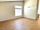 Living room with wood-look flooring, large windows, and neutral paint at 9109 W Watson Ln, Peoria, AZ 85381