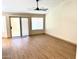 Bright living area with wood floors, modern ceiling fan, and sliding glass door at 9109 W Watson Ln, Peoria, AZ 85381