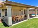 An inviting covered patio with a wooden dining set and manicured backyard with pool at 9109 W Watson Ln, Peoria, AZ 85381
