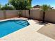 Refreshing backyard pool with a tanning ledge, set against a backdrop of lush landscaping and privacy wall at 9109 W Watson Ln, Peoria, AZ 85381