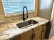 Modern kitchen sink with granite countertops, a stylish faucet, and stainless steel refrigerator at 9109 W Watson Ln, Peoria, AZ 85381