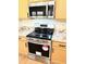 Updated stainless steel stove and microwave with updated countertops and wood cabinets in the kitchen at 9109 W Watson Ln, Peoria, AZ 85381