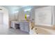 Bathroom featuring granite countertops, vanity, and a relaxing soaking tub at 9814 W Menadota Dr, Peoria, AZ 85382