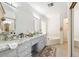 Bright bathroom featuring a double vanity with granite countertops and a separate soaking tub at 9814 W Menadota Dr, Peoria, AZ 85382