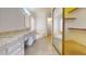 Bathroom with dual sinks, granite countertops, soaker tub, and large closet at 9814 W Menadota Dr, Peoria, AZ 85382