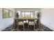 Dining room with rustic wood table, black-and-white rug, and bay window at 9814 W Menadota Dr, Peoria, AZ 85382