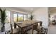 Bright dining room with rustic table, seating for six, and view into the backyard at 9814 W Menadota Dr, Peoria, AZ 85382