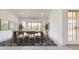 Bright dining room with rustic wood table, stylish rug, and bay window views at 9814 W Menadota Dr, Peoria, AZ 85382